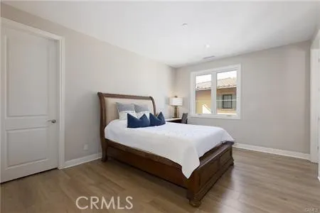 a large bed sitting in a bedroom next to a window and a wooden floor