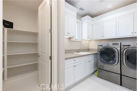 a utility room with sink dryer and washer