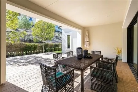 a view of a patio with table and chairs with wooden floor and fence