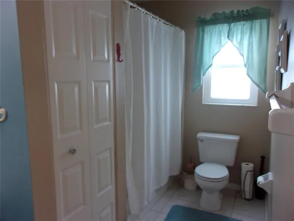 a bathroom with a toilet a sink and a window