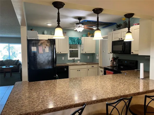 a kitchen with stainless steel appliances wooden floor dining table and chairs