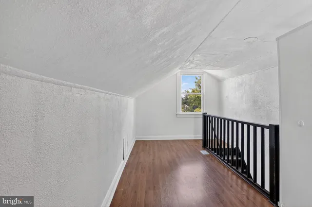 a view of a hallway with wooden floor and stairs