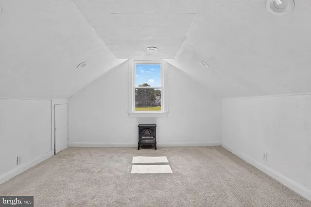 an empty room with a fireplace and window