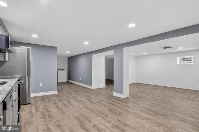 a view of empty room with wooden floor