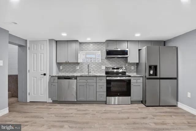 a kitchen with stainless steel appliances granite countertop a stove a sink and a refrigerator