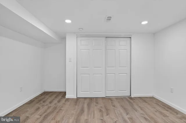 a view of a big room with wooden floor and windows