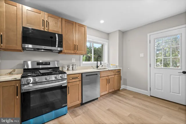 a kitchen with stainless steel appliances a stove a microwave and white cabinets