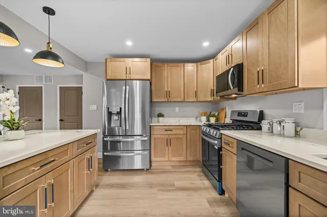 a kitchen with stainless steel appliances granite countertop a refrigerator a stove and a sink