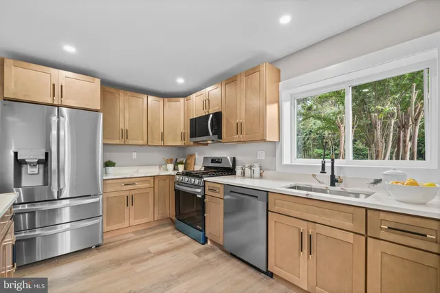 a kitchen with a sink stainless steel appliances and window
