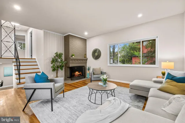 a living room with furniture a fireplace and a table with wooden floor