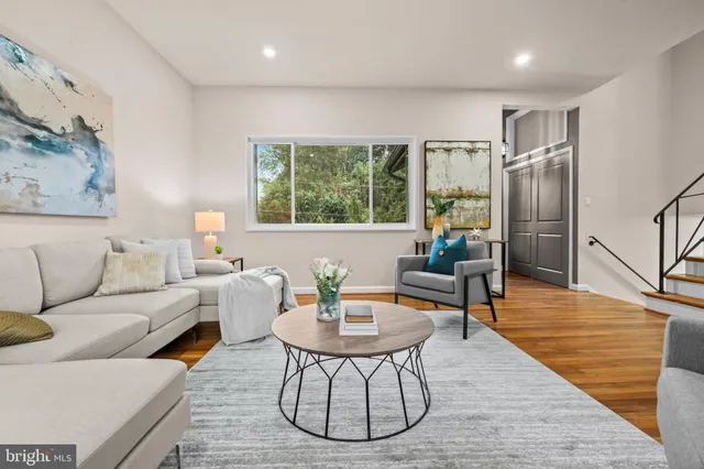 a living room with furniture a table and a large window