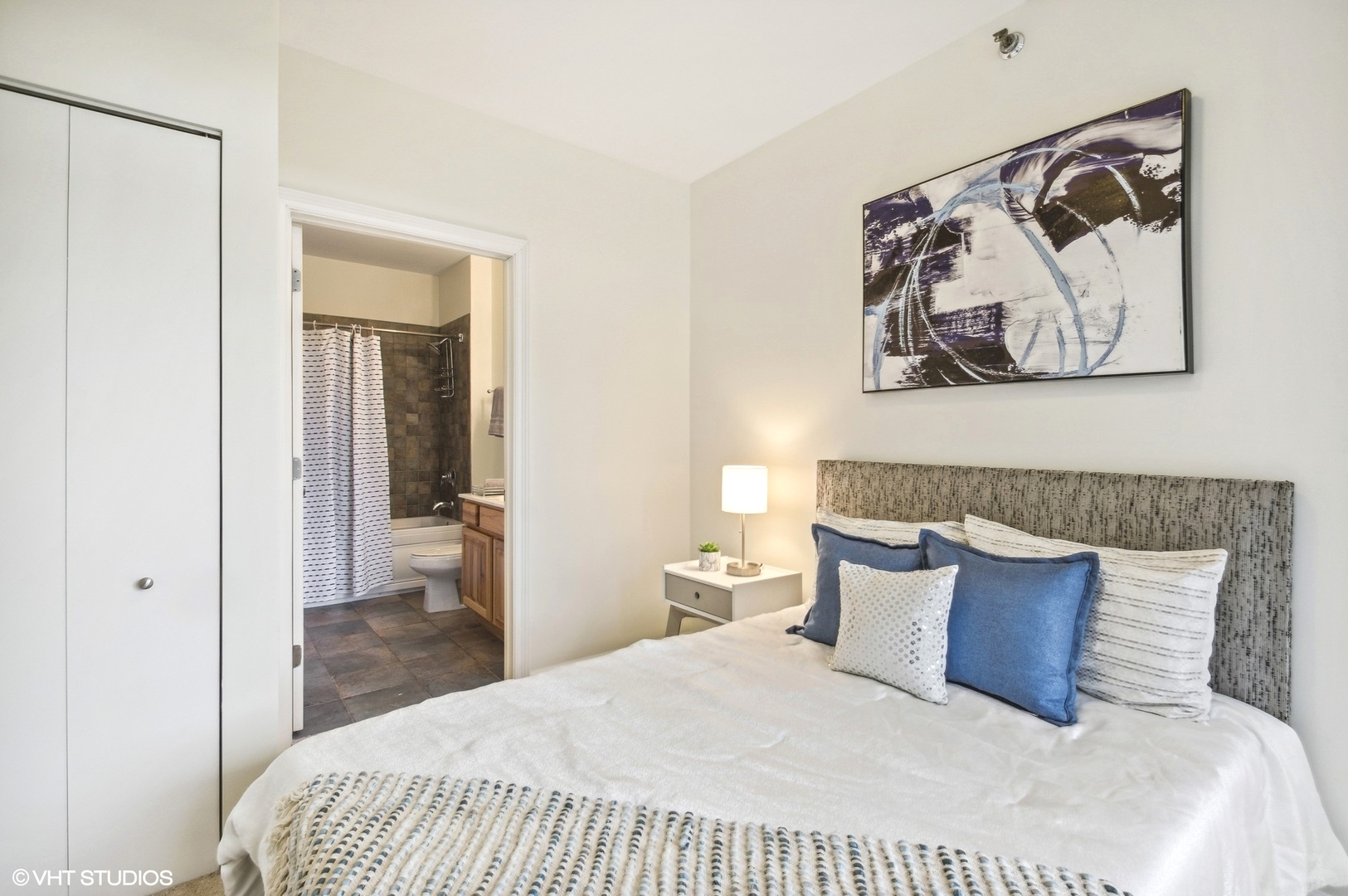 1111 South Wabash Avenue, Unit 706 Chicago, IL 60605 - Photo 13 of 19 a bedroom with a large bed and a painting on the wall