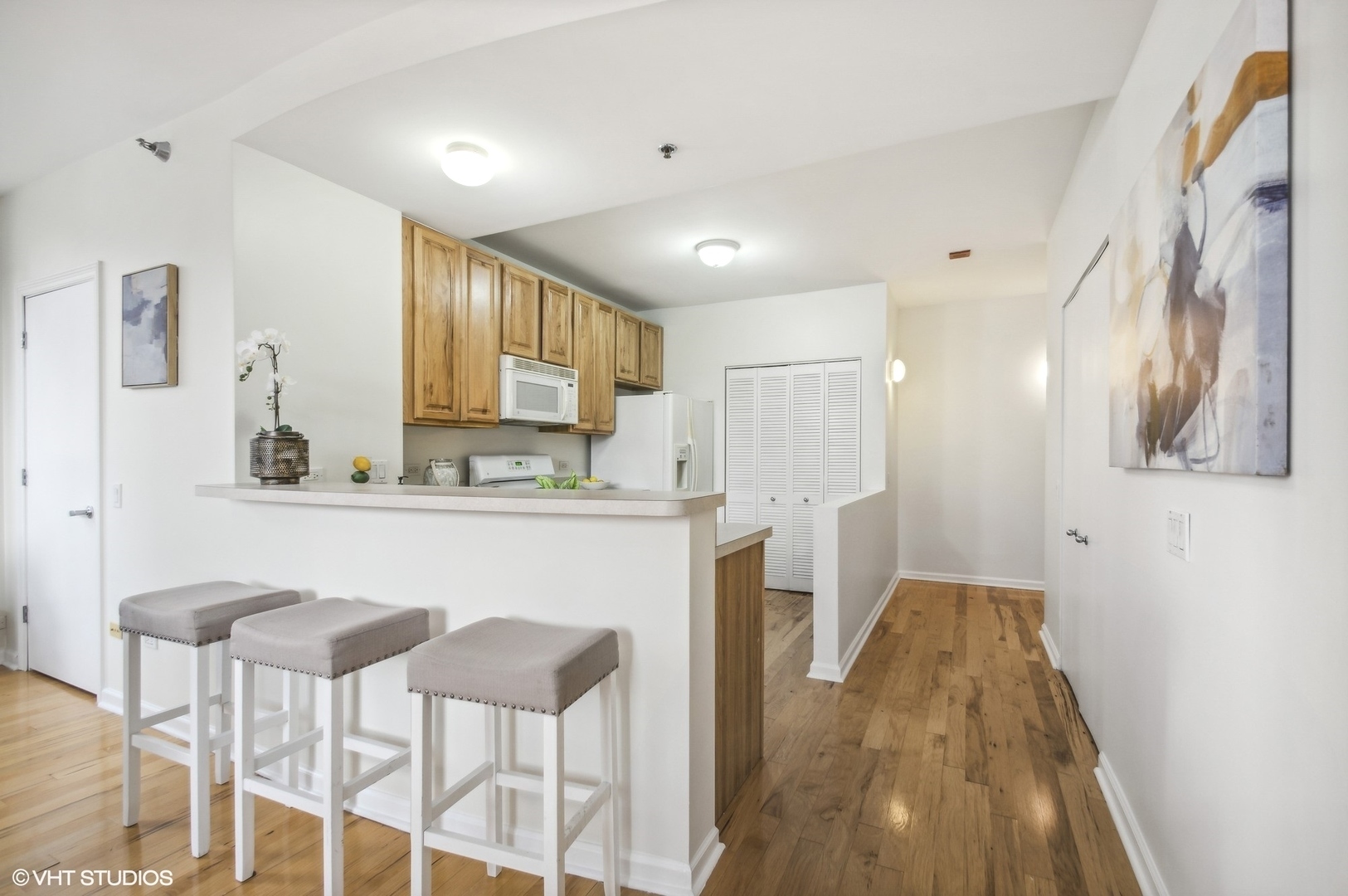 1111 South Wabash Avenue, Unit 706 Chicago, IL 60605 - Photo 6 of 19 a kitchen with stainless steel appliances kitchen island granite countertop a refrigerator a stove a sink dishwasher and white cabinets with wooden floor