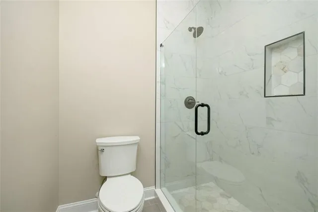 a bathroom with a toilet and a shower