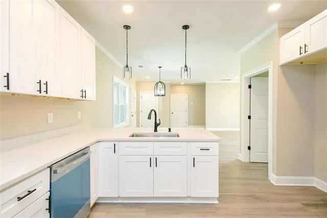 a view of a kitchen with kitchen island a sink stainless steel appliances and cabinets