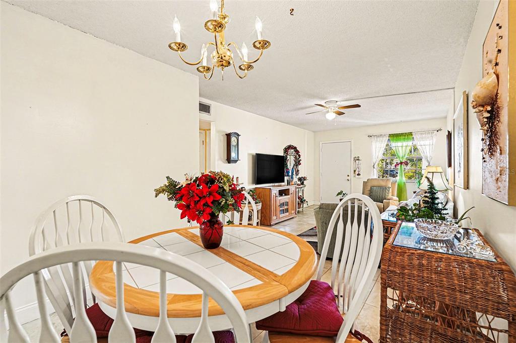 4742 Azalea Drive, Unit 103 New Port Richey, FL 34652 - Photo 11 of 33 a view of a dining room with furniture and a chandelier