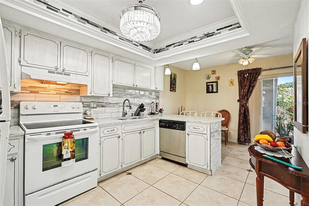 4742 Azalea Drive, Unit 103 New Port Richey, FL 34652 - Photo 12 of 33 a kitchen with stainless steel appliances granite countertop a stove a sink and a refrigerator