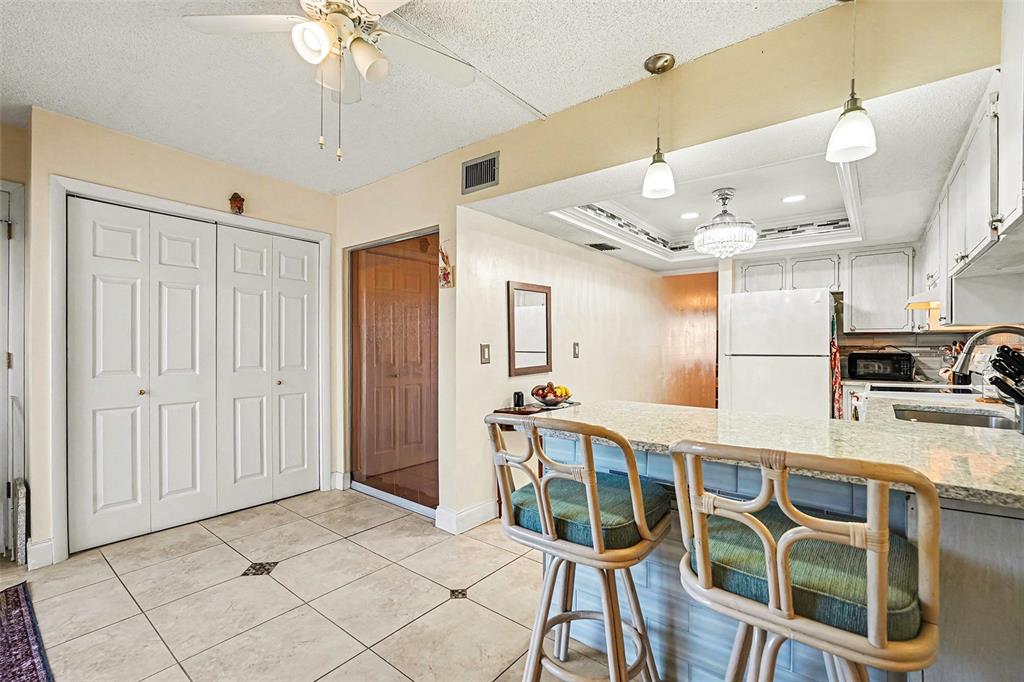 4742 Azalea Drive, Unit 103 New Port Richey, FL 34652 - Photo 14 of 33 a kitchen with stainless steel appliances kitchen island granite countertop a refrigerator and microwave