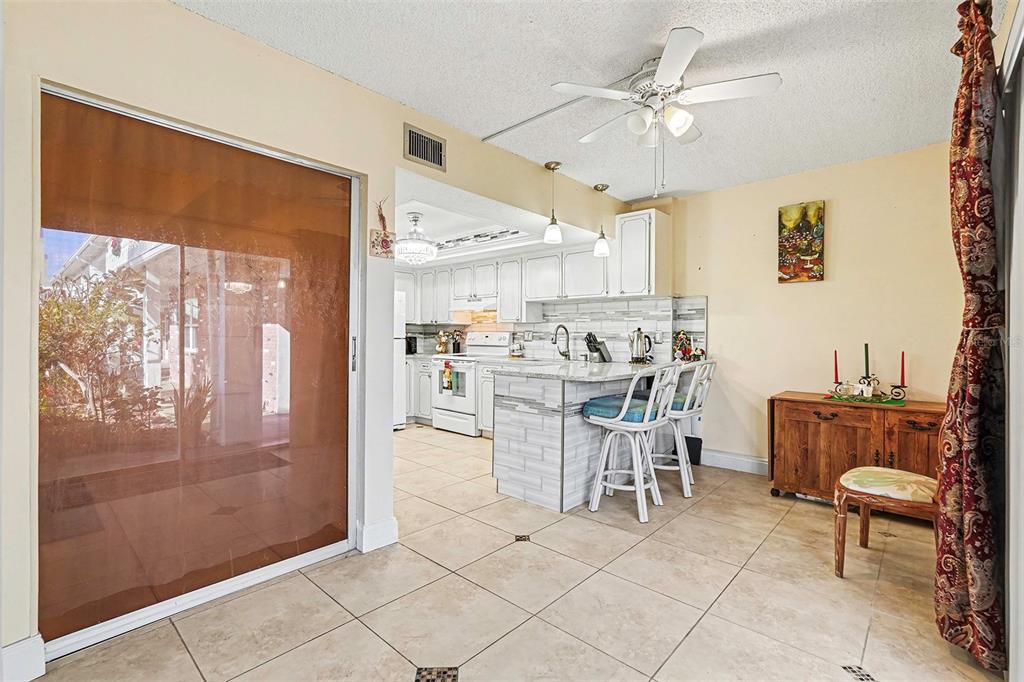4742 Azalea Drive, Unit 103 New Port Richey, FL 34652 - Photo 15 of 33 a view of kitchen with dining area a kitchen island white cabinetry and a refrigerator