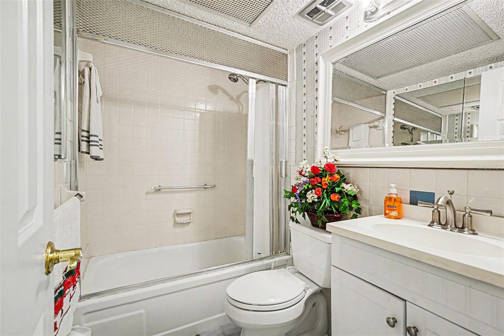4742 Azalea Drive, Unit 103 New Port Richey, FL 34652 - Photo 16 of 33 a bathroom with a shower a toilet and a shower curtain