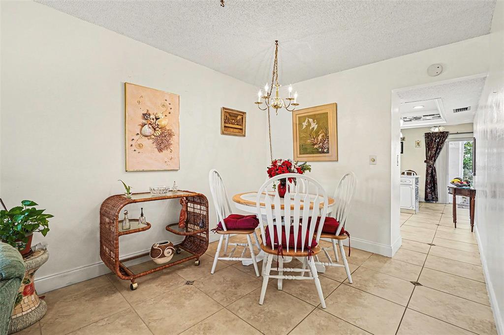 4742 Azalea Drive, Unit 103 New Port Richey, FL 34652 - Photo 9 of 33 a dining room with furniture and chandelier