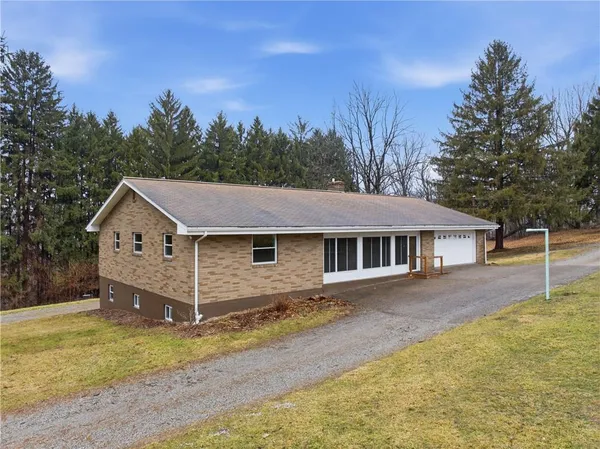 a view of a yard in front of a house with large trees