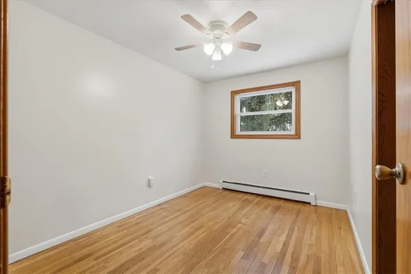 an empty room with a window and a ceiling fan