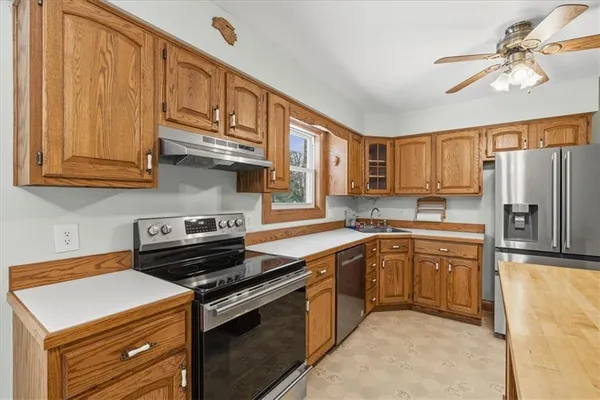 a kitchen with stainless steel appliances granite countertop a stove refrigerator sink and cabinets