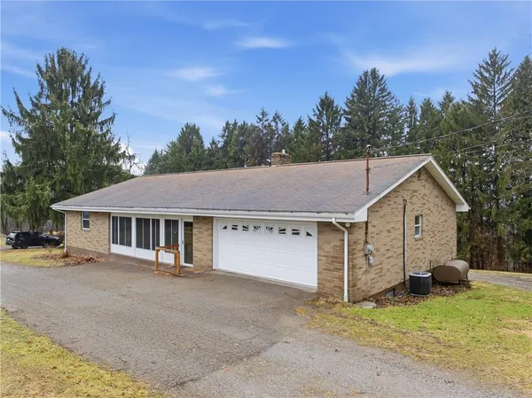 a view of a white house with a large space and a yard