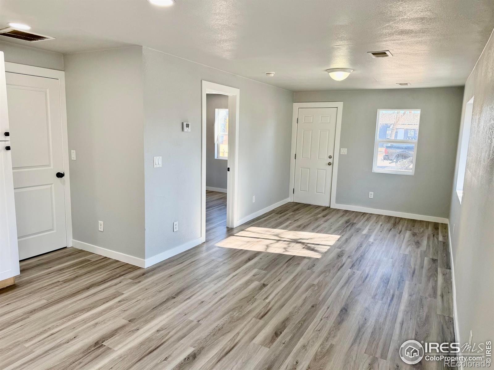 2015 5th Avenue, Unit A Greeley, CO 80631 - Photo 11 of 15 an empty room with wooden floor and windows