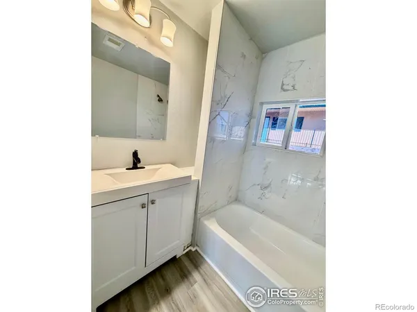 a bathroom with a tub sink and mirror