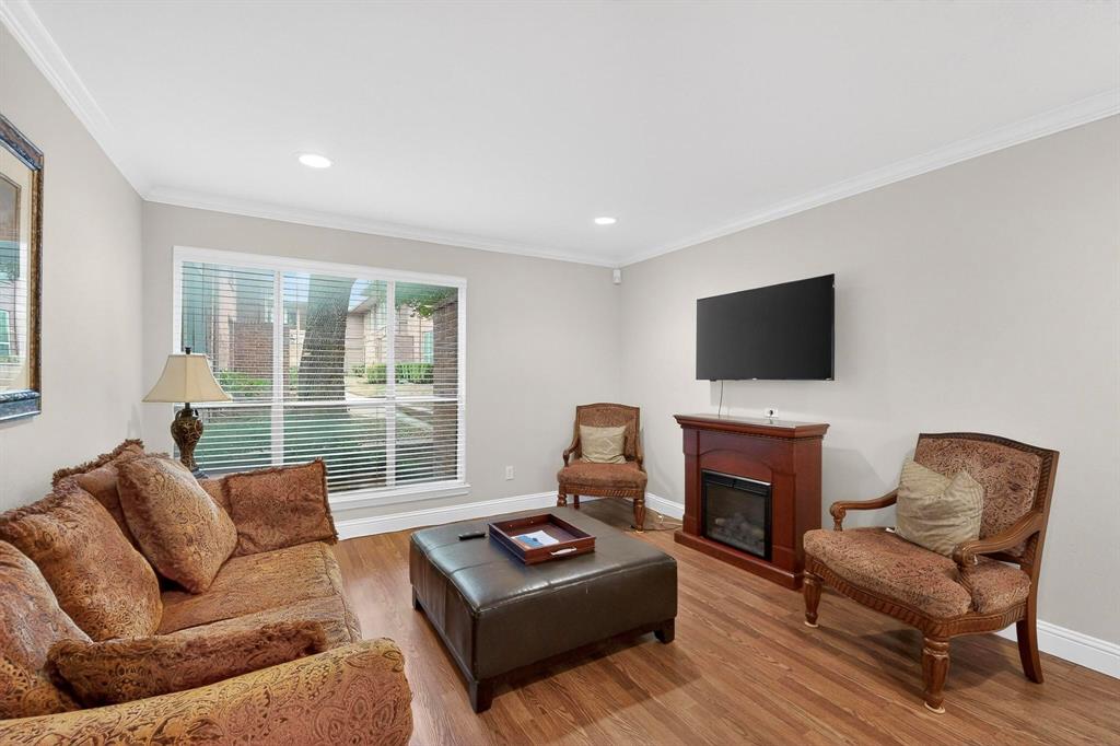 10534 Stone Canyon Road, Unit 111 Dallas, TX 75230 - Photo 2 of 14 a living room with furniture a flat screen tv and a large window