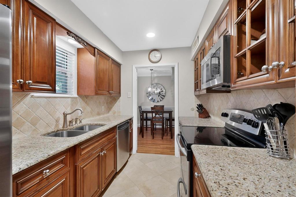 10534 Stone Canyon Road, Unit 111 Dallas, TX 75230 - Photo 6 of 14 a kitchen with stainless steel appliances granite countertop a sink and cabinets