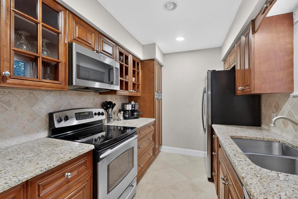 10534 Stone Canyon Road, Unit 111 Dallas, TX 75230 - Photo 7 of 14 a kitchen with stainless steel appliances granite countertop a sink stove and refrigerator