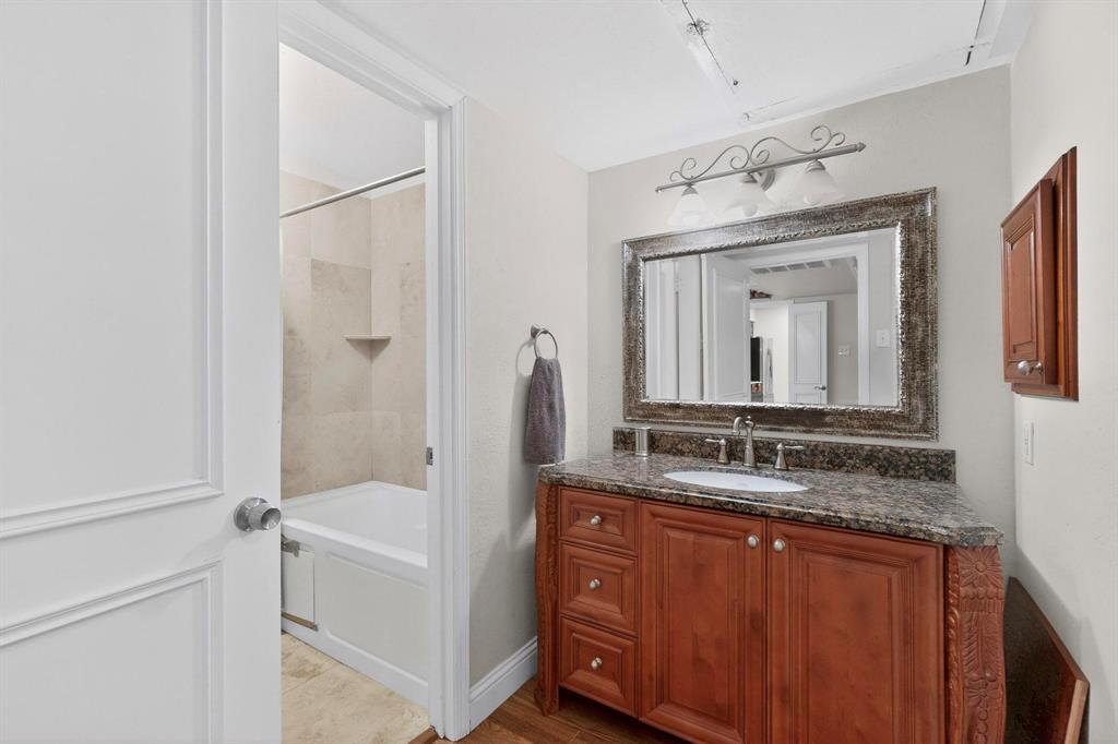 10534 Stone Canyon Road, Unit 111 Dallas, TX 75230 - Photo 9 of 14 a bathroom with a granite countertop tub sink and mirror