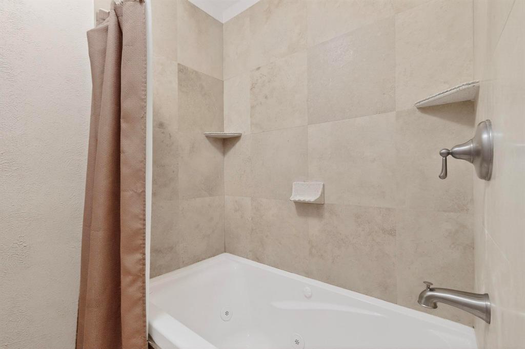 10534 Stone Canyon Road, Unit 111 Dallas, TX 75230 - Photo 10 of 14 a bathroom with a white bath tub and a shower
