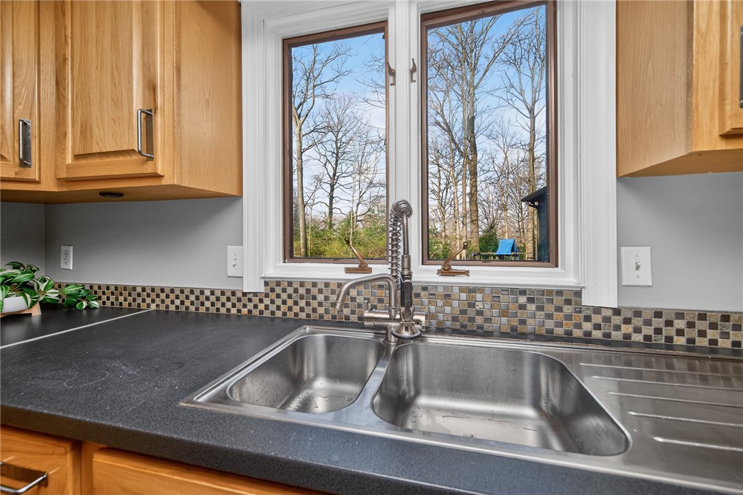4747 Fawnwood Road Dayton, OH 45429 - Photo 15 of 58 This bright kitchen features a double-basin sink set against a window, offering a view of nature.