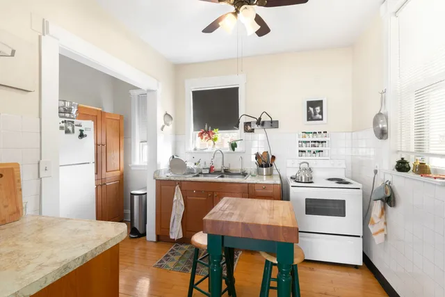 a kitchen with stainless steel appliances kitchen island a table chairs in it and wooden floors