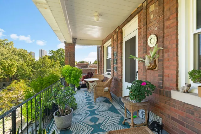 a view of a porch with chairs and potted plants