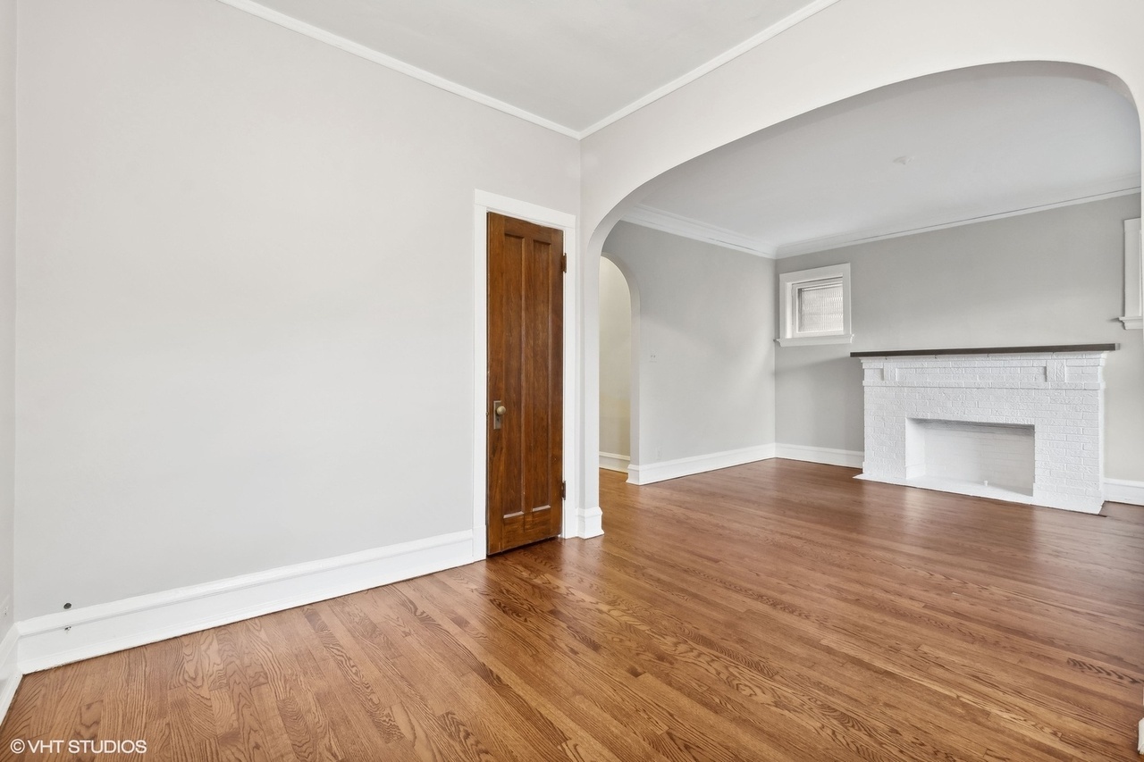 1311 West Thorndale Avenue Chicago, IL 60660 - Photo 15 of 28 an empty room with wooden floor and fireplace
