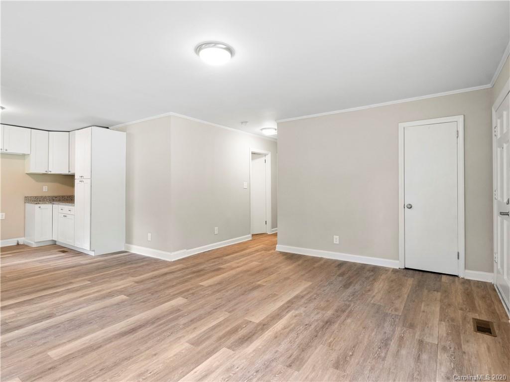 4152 Blenhein Road Charlotte, NC 28208 - Photo 10 of 34 a view of an empty room with wooden floor and a kitchen