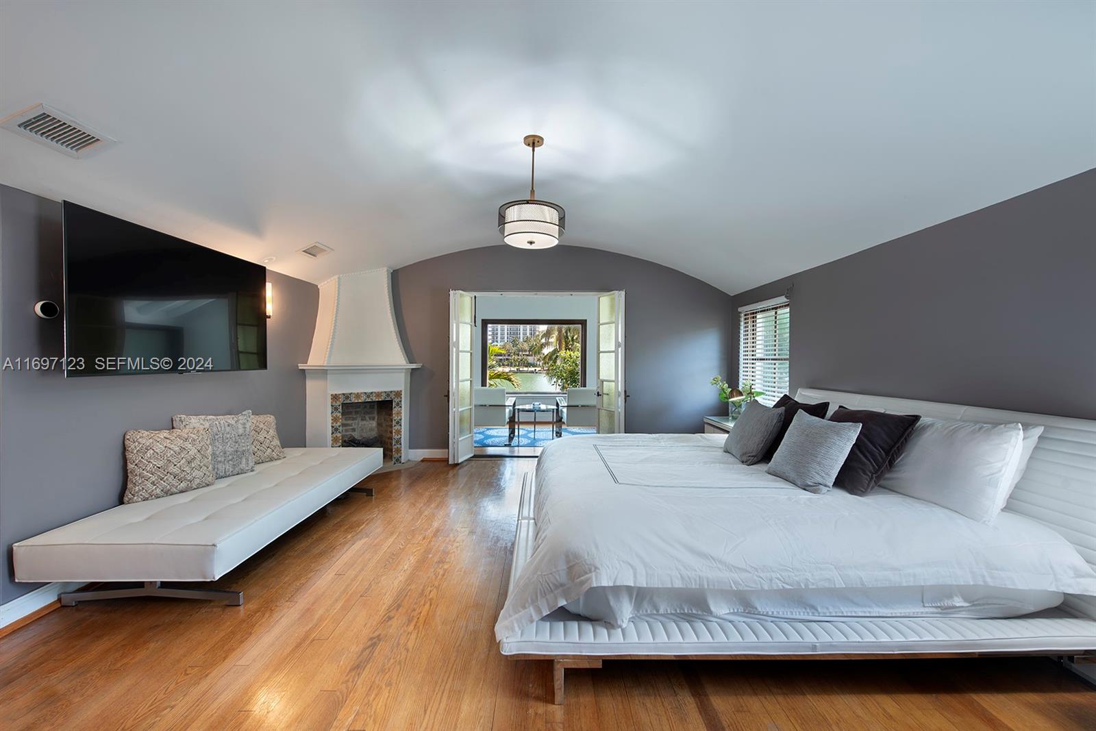 4745 Pine Tree Drive Miami Beach, FL 33140 - Photo 16 of 35 a bedroom with a bed and a flat screen tv