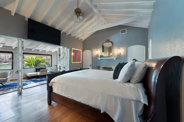 a bedroom with a bed window and a mirror