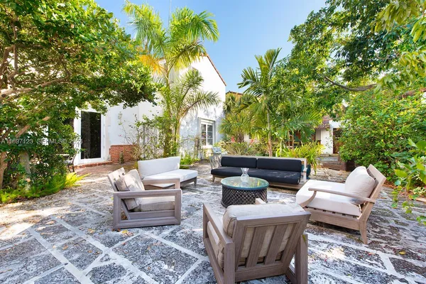 a view of a patio with couches and a table and chairs with garden view