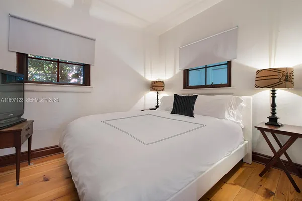 a bedroom with a bed and a lamp on dresser