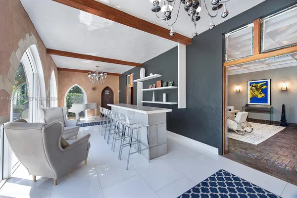 a living room with furniture a chandelier and a window