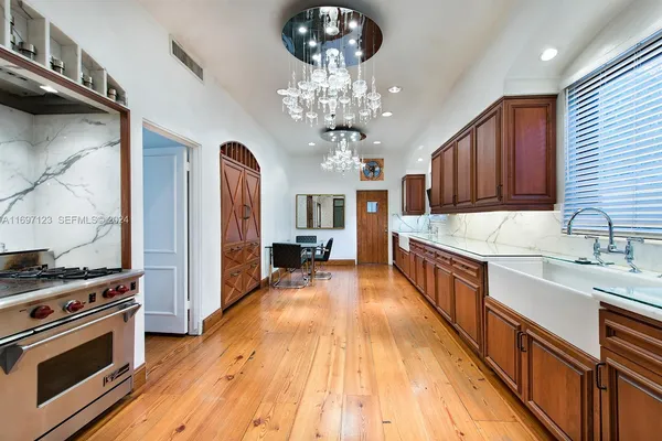 a large kitchen with stainless steel appliances granite countertop a stove oven and a wooden floors