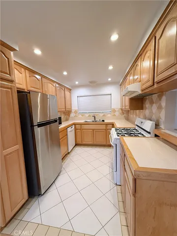 a kitchen with refrigerator cabinets and wooden floor
