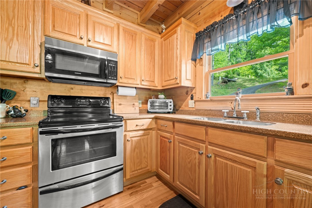 613 Silas Creek Road Lansing, NC 28643 - Photo 17 of 40 a kitchen with granite countertop white cabinets white stainless steel appliances and a sink