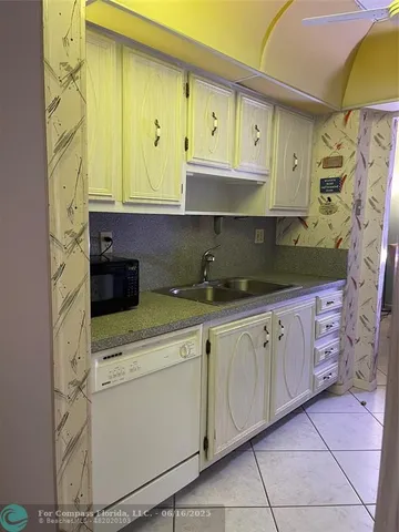 a kitchen with cabinets appliances and a sink